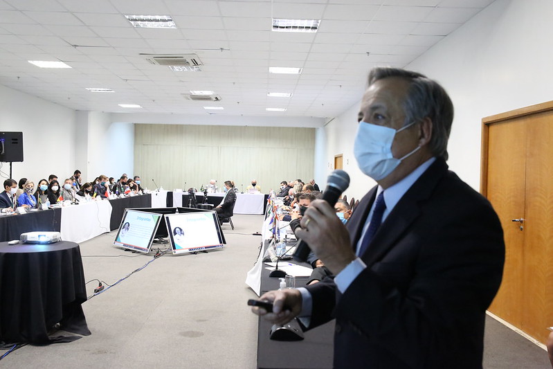 Presidente do CRMV-SP, Mário Eduardo Pulga, está de pé, com máscara, e falando ao microfone em frente dos demais convidados