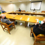 Todos sentados, com distanciamento entre si, em cadeiras dispostas ao redor de mesa no formato de "U", estão os representantes do CRMV-SP e da Prefeitura de São José dos Campos