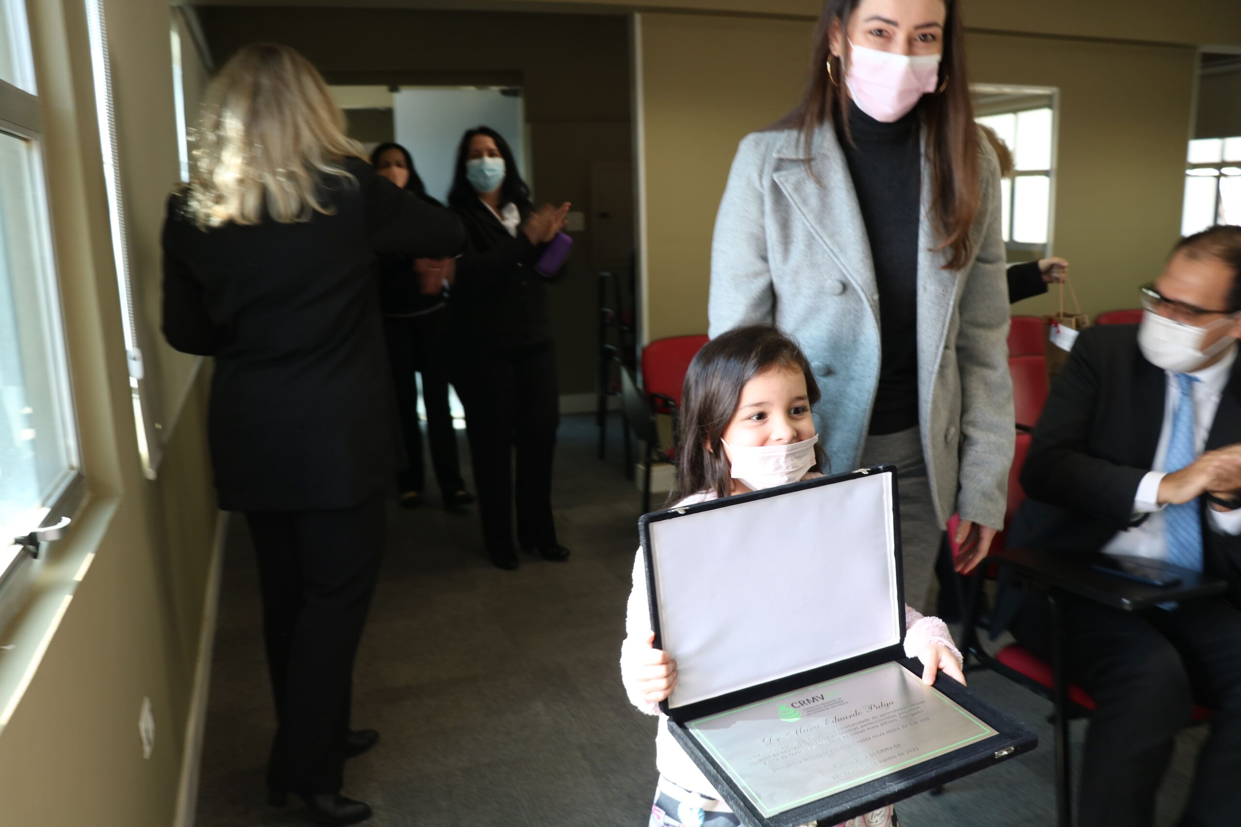 Filha e esposa do presidente Mário Eduardo Pulga, entregam placa em homenagem ao trabalho realizado no CRMV-SP.