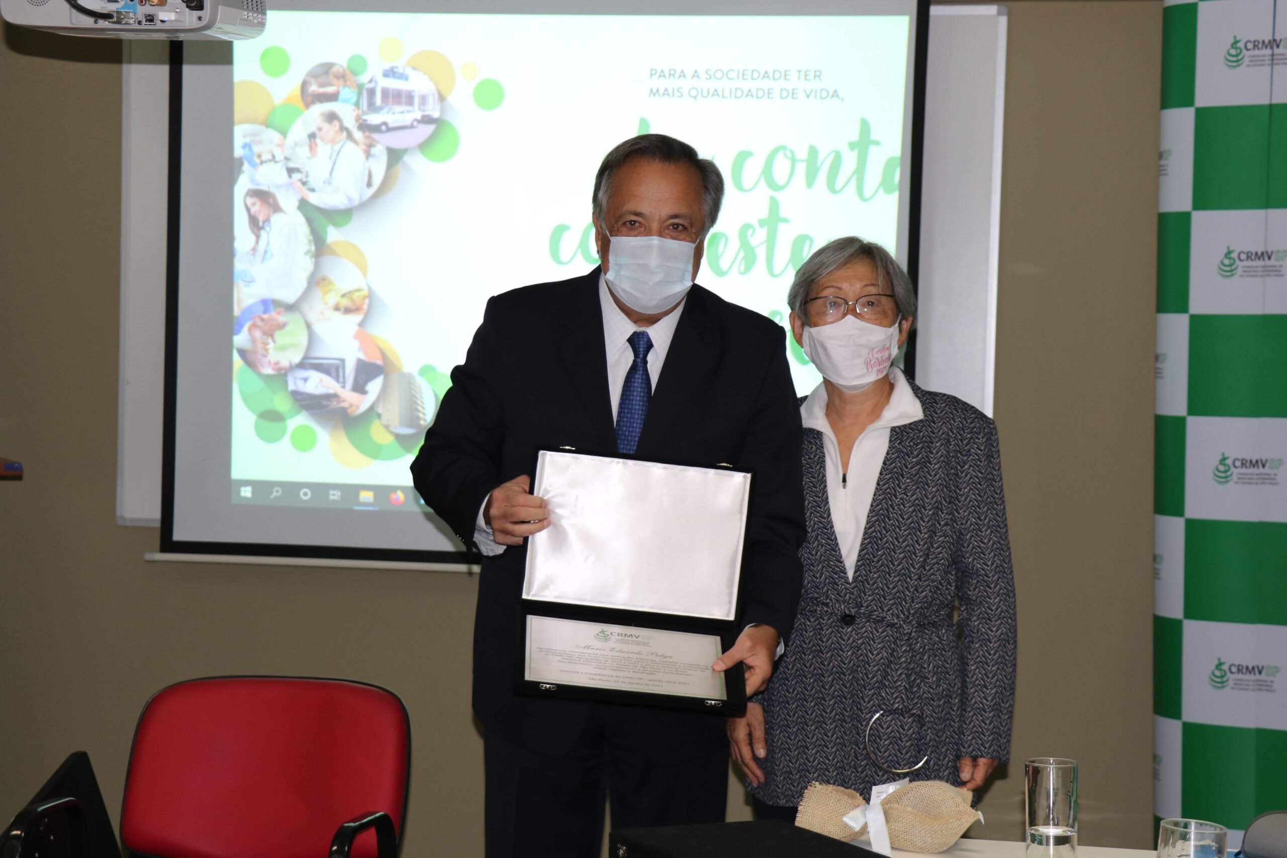 Mário Eduardo Pulga exibe a placa recebida ao lado de Mitika Hagiwara, conselheira efetiva.