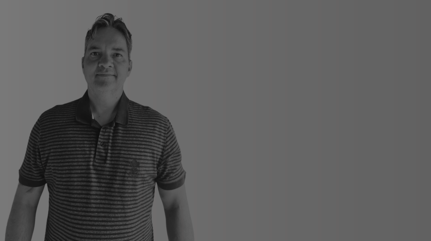Homem branco em pé sorridente pousando para foto, ele veste blusa listrada de mangas curtas. É Cesar Daniel Kruger.