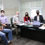 Diretores e assessores do CRMV-SP estão de máscara, olhando para a câmera, sentados ao entorno de uma mesa com cadernos e computadores. Na foto está também o presidente escolhido para a Comissão de Representantes Regionais.