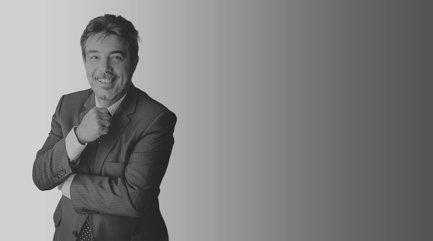 Homem branco usando terno sorri para foto. É o dr. Ariovaldo Zani.