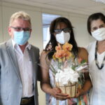Em pé e usando máscaras a imagem mostra o presidente do Conselho, ao lado da colaboradora Cecília que segura um arrajnjo de flores com a Tesoureira do CRMV-SP à sua direita.
