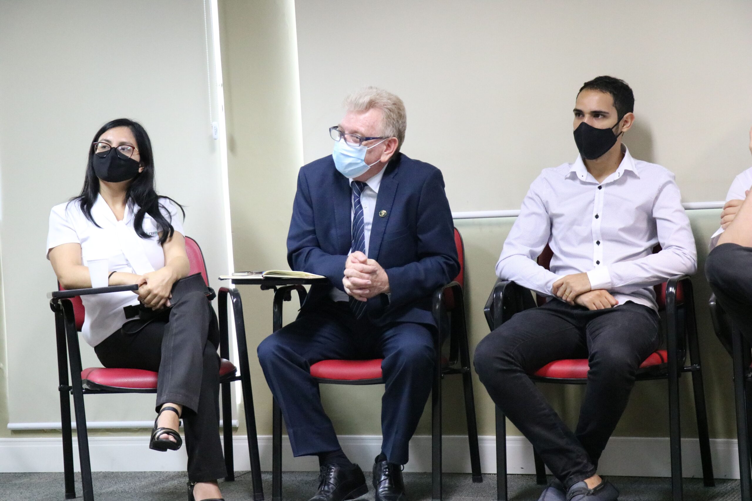 O presidente do Conselho está sentado de máscara entre dois colaboradores das Unidades Regionais. Uma mulher à esquerda e um homem à direita.