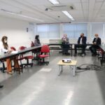 Na foto aparecem mesas dispostas em formato de "U" em cujo entorno estão sentadas sete pessoas, com distanciamento entre si e vestindo máscaras. Liderando a reunião, o presidente e o vice-presidente do CRMV-SP.