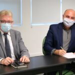 Na foto estão sentados lado a lado e de máscara, posando para a câmera, o presidente do CRMV-SP e o presidente da Comissão de Nutrição Animal, que faz a menção de assinar o termo de posse.