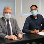 Na foto estão sentados lado a lado e de máscara, posando para a câmera, o presidente do CRMV-SP e o o médico-veterinário e zootecnista João Paulo Fernandes Santos, que faz a menção de assinar o termo de posse como integrante da Comissão de Nutrição Animal.