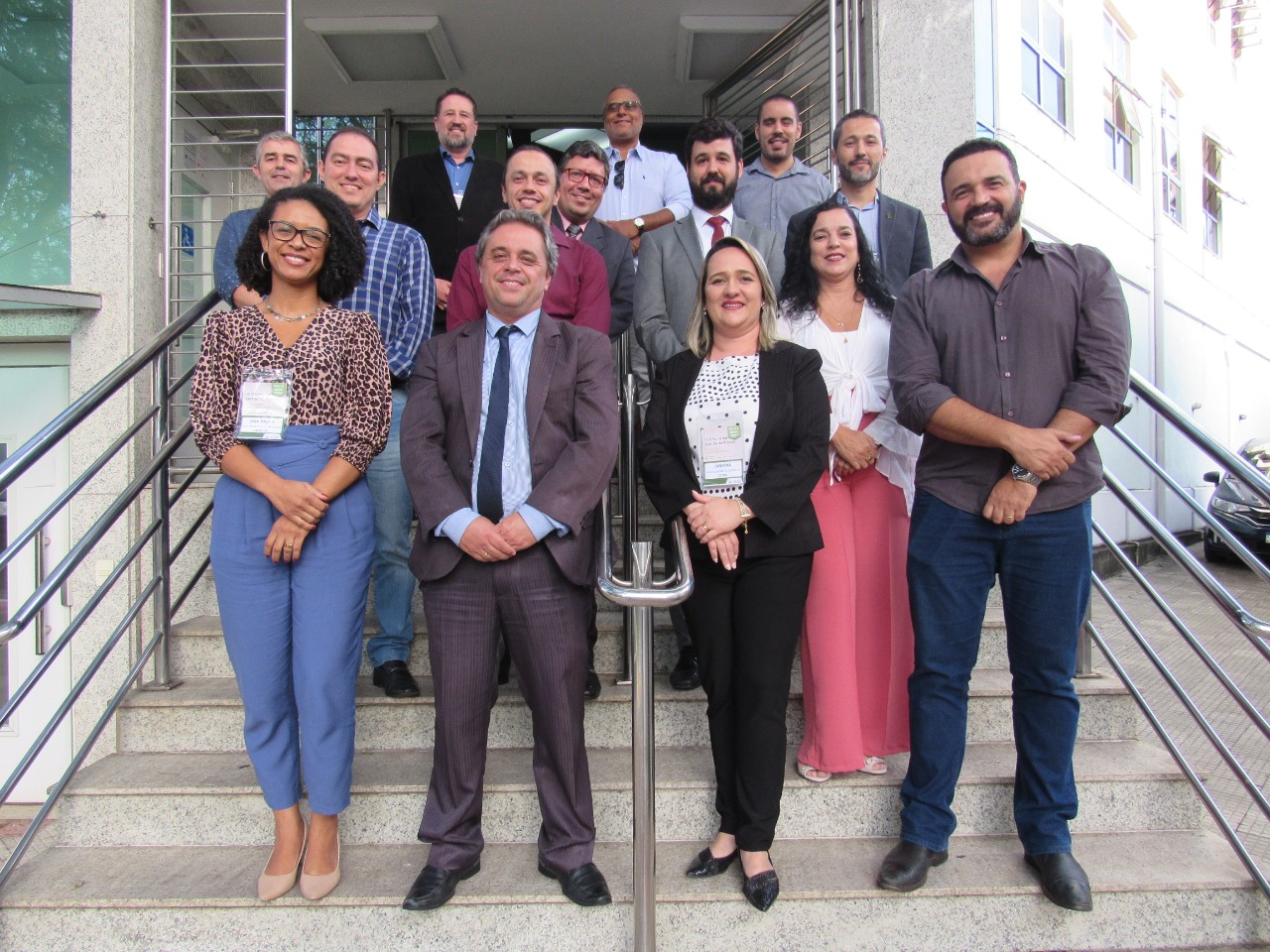 Representantes de regionais do Sul e Sudeste posam para foto em frente a sede do CRMV-MG. O coordenador financeiro do CRMV-SP, Emanoel Coelho, aparece na foto sorrindo vestindo um suéter vinho.