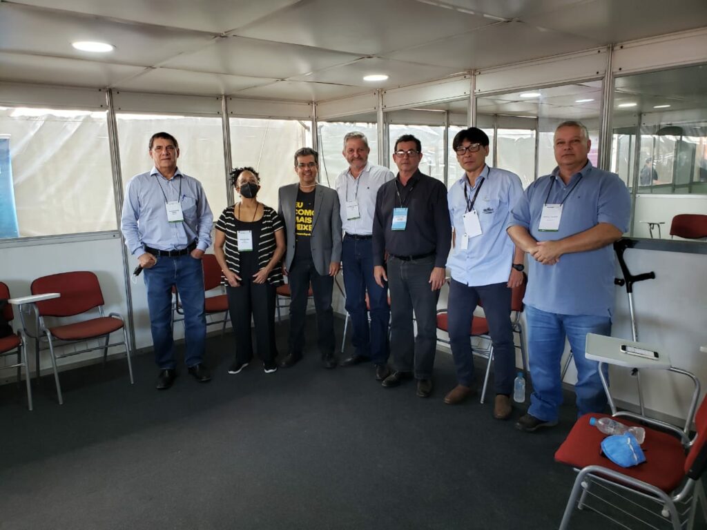 Integrantes da Comissão de Aquicultura, o vice-presidente do CRMV-SP e o presidente da Peixes BR posam para a foto, todos de pé olhando em direção à câmera.
