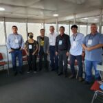 Integrantes da Comissão de Aquicultura, o vice-presidente do CRMV-SP e o presidente da Peixes BR posam para a foto, todos de pé olhando em direção à câmera.