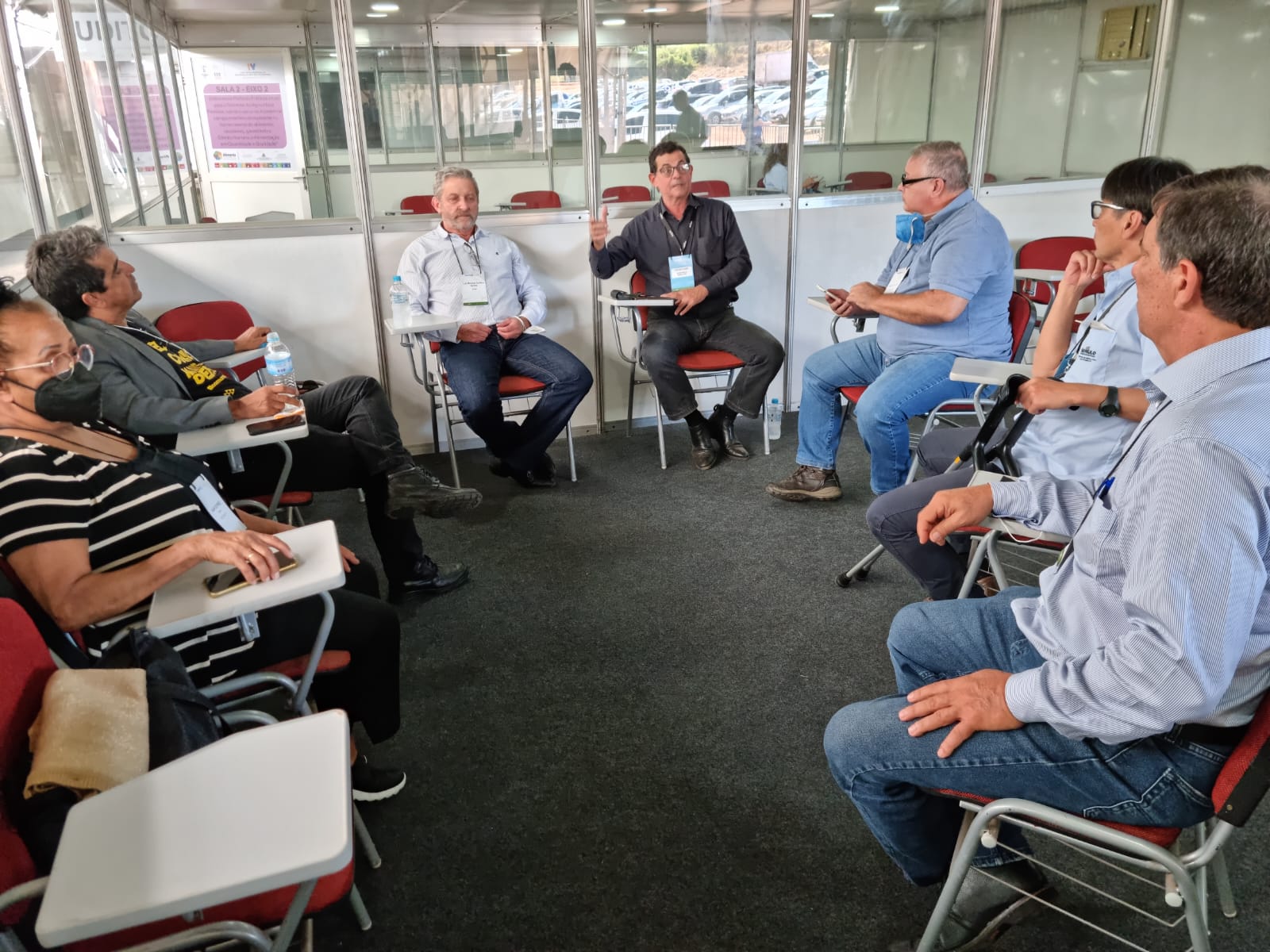 Integrantes da Comissão de Aquicultura estão sentados em carteiras universitárias dispostas em forma de U. Em destaque está o vice-presidente do Conselho, Fernando Gomes Buchala falando e gesticulando.