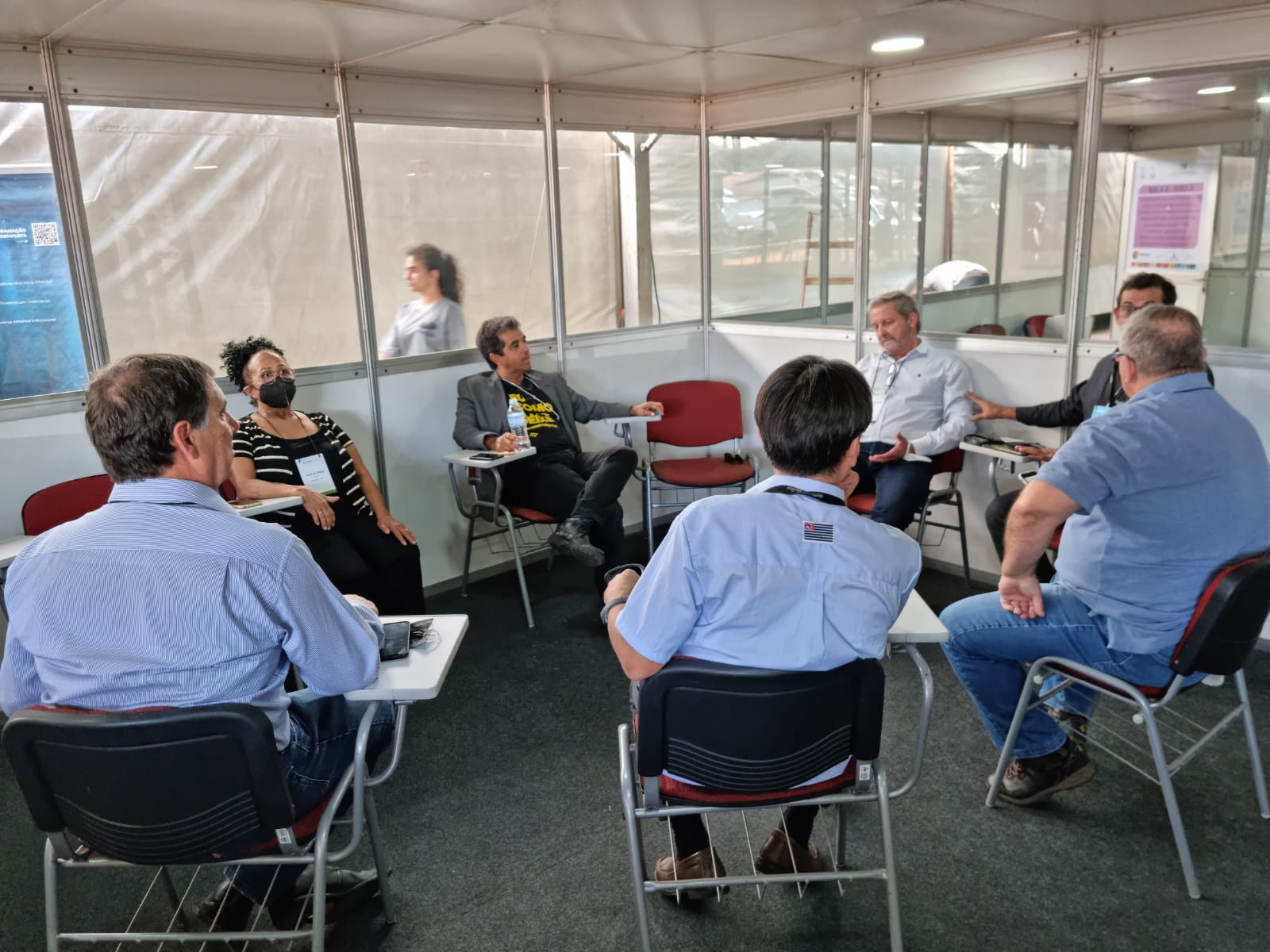 Integrantes da Comissão de Aquicultura, vice-presidente do CRMV-SP e presidente da Peixes Br estão sentados em carteiras universitárias dialogando. Alguns integrantes estão de costas para a câmera.