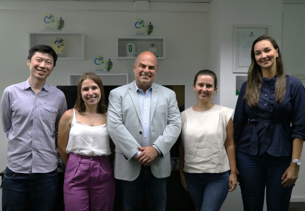 Novos fiscais e o vice-presidente do CRMV-SP (ao centro) posam de pé sorrindo para a foto.