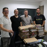 Membros da Comissão de Tomada de Contas do CRMV_SP posam para foto com as pilhas de processos em papel