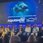 Foto mostra pessoas sentadas durante abertura da 12ª edição da Aquishow Brasil.