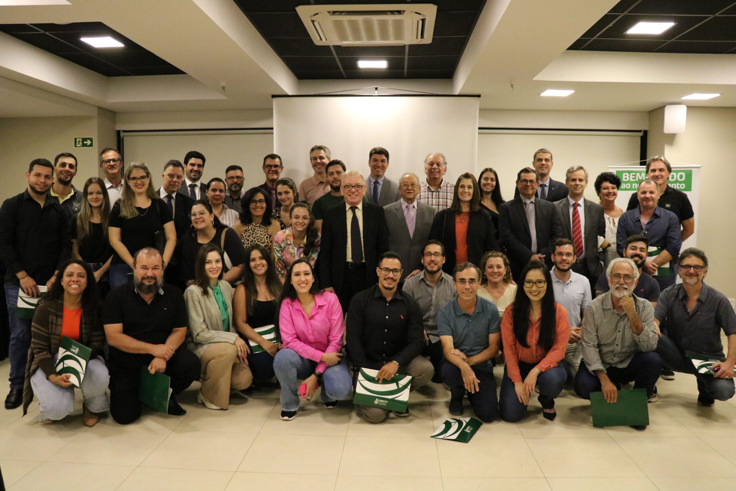 Na foto estão todos os participantes do CRMV-SP Escuta de Piracicaba. Eles posam para foto todos juntos e sorridentes. Alguns estão agachados e outros de pé. Ao centro está o presidente do CRMV-SP.