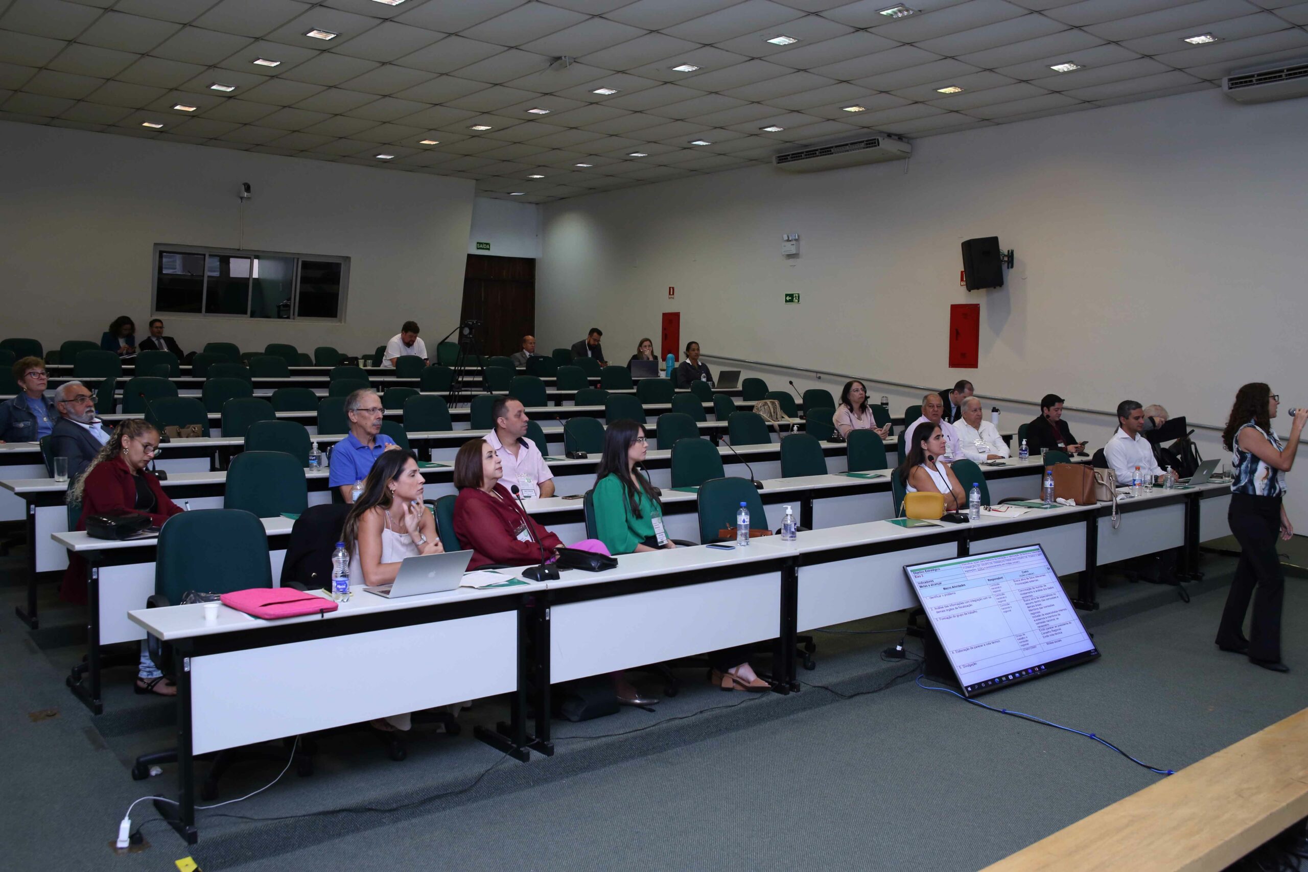 A foto mostra membros que participaram do Seminário sentados, prestando atenção no evento.