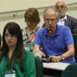 A foto mostra alguns membros dos diversos CRMVs ouvindo Ricardo Moreira Calil, médico-veterinário e presidente da Comissão Técnica de Alimentos do Conselho Regional de Medicina Veterinária do Estado de São Paulo (CRMV-SP), que está falando. Eles estão sentados.