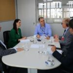 Na imagem há cinco pessoas reunidas ao entorno de uma mesa oval branca, sendo quatro homens e uma mulher. São os representantes do CRMV-SP reunidos com o subsecretário estadual de Meio Ambiente (que está na cabeceira da mesa) e a coordenadora de Fauna Silvestre.