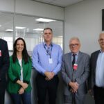 Na imagem há cinco pessoas, sendo quatro homens e uma mulheres. Estão todos de pé, lado a lado, sorrindo para a câmera. Eles são os representantes do CRMV-SP e da subsecretaria de Estado do Meio Ambiente.