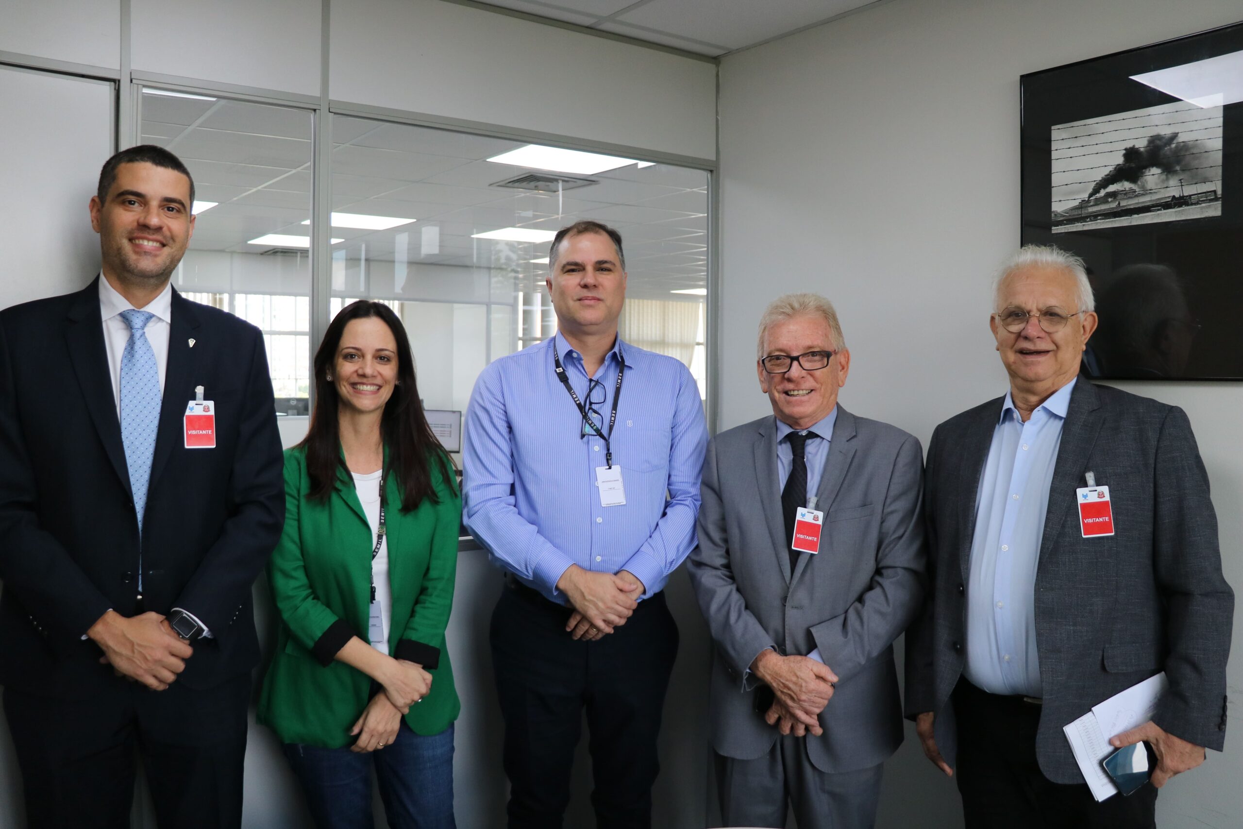 Na imagem há cinco pessoas, sendo quatro homens e uma mulheres. Estão todos de pé, lado a lado, sorrindo para a câmera. Eles são os representantes do CRMV-SP e da subsecretaria de Estado do Meio Ambiente.