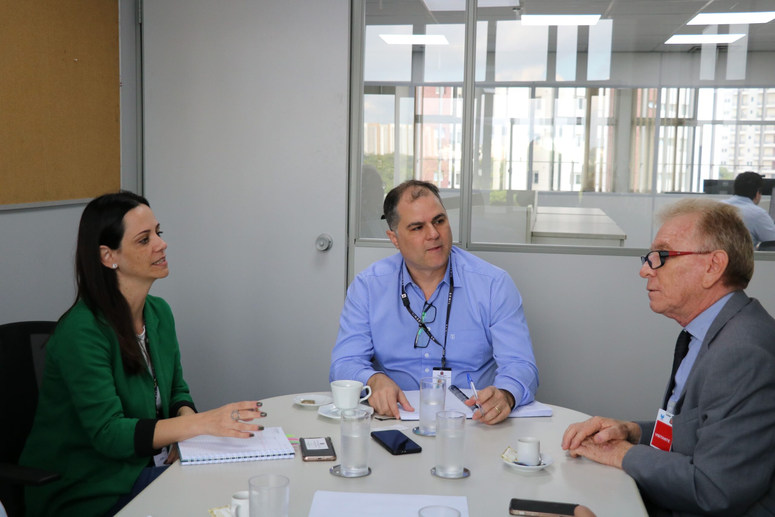 Na imagem há três pessoas reunidas ao entorno de uma mesa oval branca, sendo dois homens e uma mulher. São eles o subsecretário estadual de Meio Ambiente (que está na cabeceira da mesa), a coordenadora de Fauna Silvestre, e o presidente do CRMV-SP.