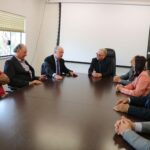 Na foto aparecem todos os representantes do CRMV-SP, da associação de médicos-veterinários de Piracicaba e o delegado de polícia diretor do Deinter. Estão todos sentados ao entorno de uma grande mesa de madeira. Na cabeceira está o presidente do Conselho. Todos estão voltados para o delegado de polícia, que explana sobre maus-tratos.