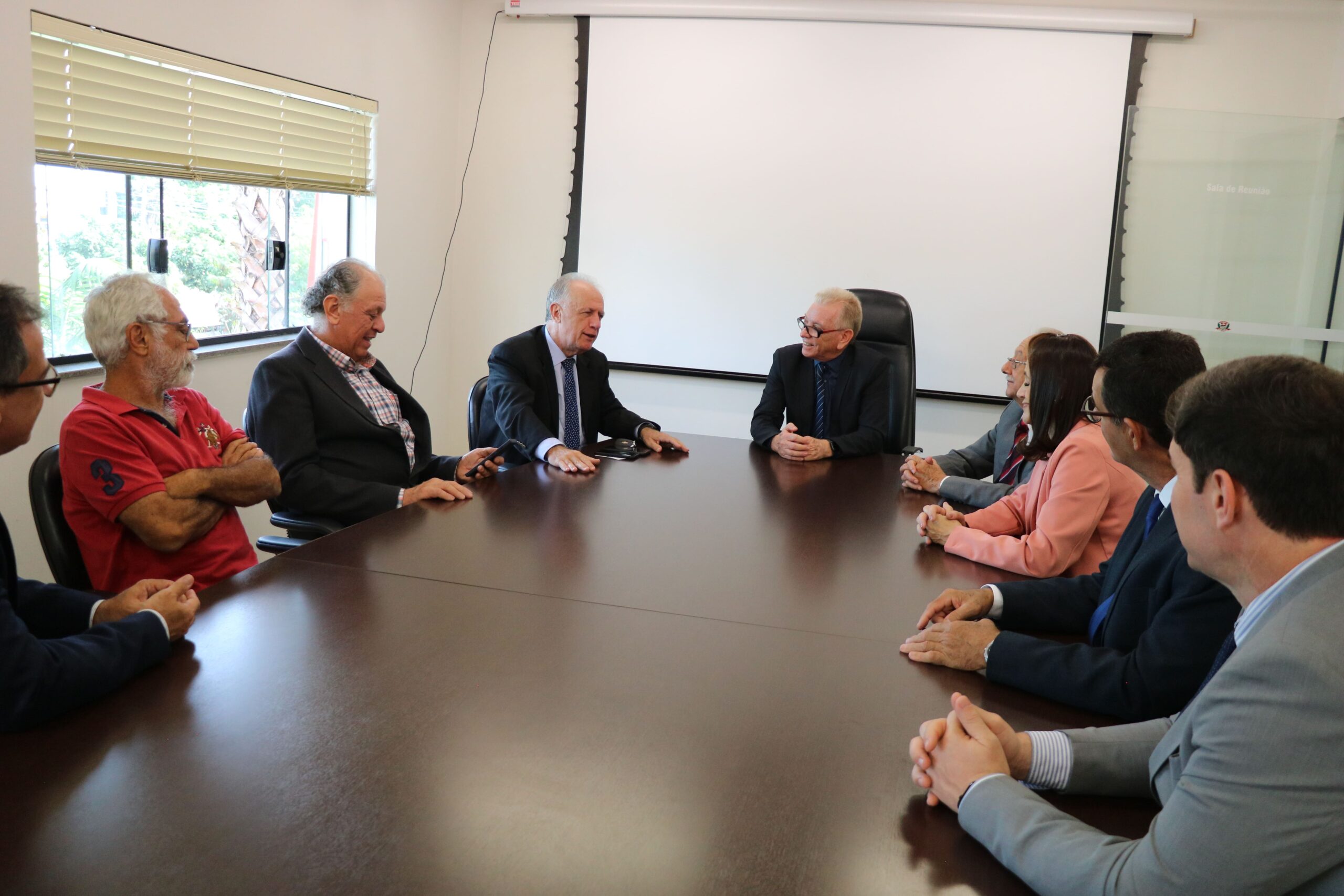 Na foto aparecem todos os representantes do CRMV-SP, da associação de médicos-veterinários de Piracicaba e o delegado de polícia diretor do Deinter. Estão todos sentados ao entorno de uma grande mesa de madeira. Na cabeceira está o presidente do Conselho. Todos estão voltados para o delegado de polícia, que explana sobre maus-tratos.
