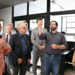 Na foto, os representantes do CRMV-SP estão acompanhados pelo diretor de campus e por um professor da Unimed. Eles visitam a estrutura da instituição e recebem explicações do diretor de campis. Na imagem há sete homens e uma mulher.