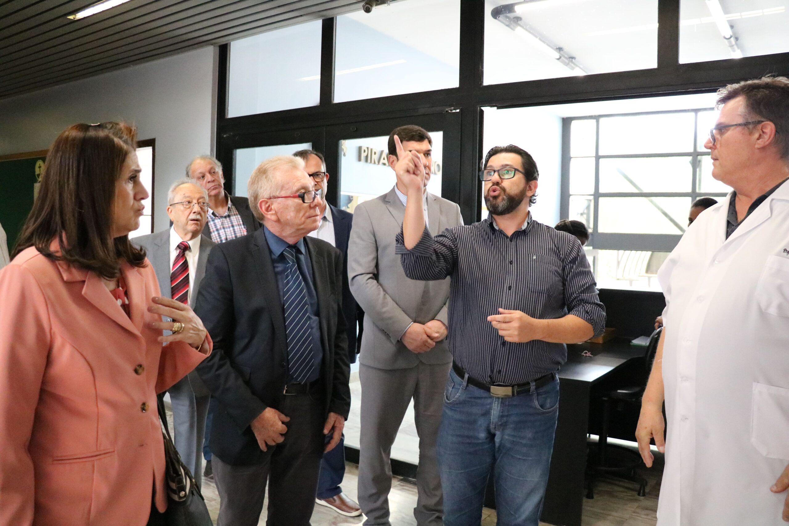 Na foto, os representantes do CRMV-SP estão acompanhados pelo diretor de campus e por um professor da Unimed. Eles visitam a estrutura da instituição e recebem explicações do diretor de campis. Na imagem há sete homens e uma mulher.