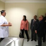 Na foto aparecem cinco representantes do CRMV-SP, acompanhados pelo responsável da clínica da Unimep. Eles estão dentro de uma sala de atendimento e na imagem aparece uma mesa de aço inos com suporte para medicações. Há cinco homens e uma mulher.