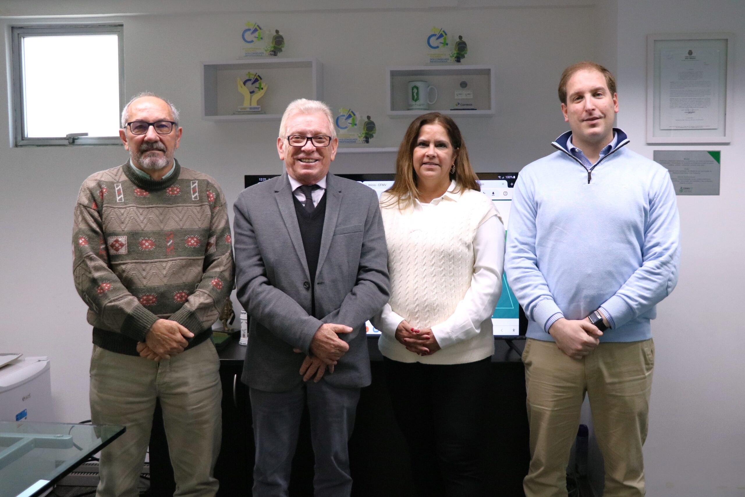 Na foto há três homens e uma mulher. Estão todos de pé, posados lado a lado e olhando para a câmera. Tratam-se de representantes do CRMV-SP e da Associação de Médicos-veterinários de Osasco e Região.