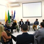 Na foto há 15 pessoas sentadas em carteiras escolares formando uma roda de conversa. Em destaque aparecem os presidentes da Ammvet e o secretário de Bem-estar Animal. No fundo da sala há bandeiras do Brasil, do estado de São Paulo, do município de Mogi Guaçu e do Cegep.
