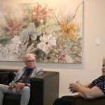 Na foto aparecem o presidente e a tesoureira do CRMV-SP sentados em um sofá na cor preta, e a presidente da Câmara de Araçatuba em uma poltrona também na cor preta. Ao fundo, um quadro com temática de flores em tons pastéis.