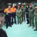 Pessoas membros participam de ação no metrô de São Paulo. Eles posam para a foto.