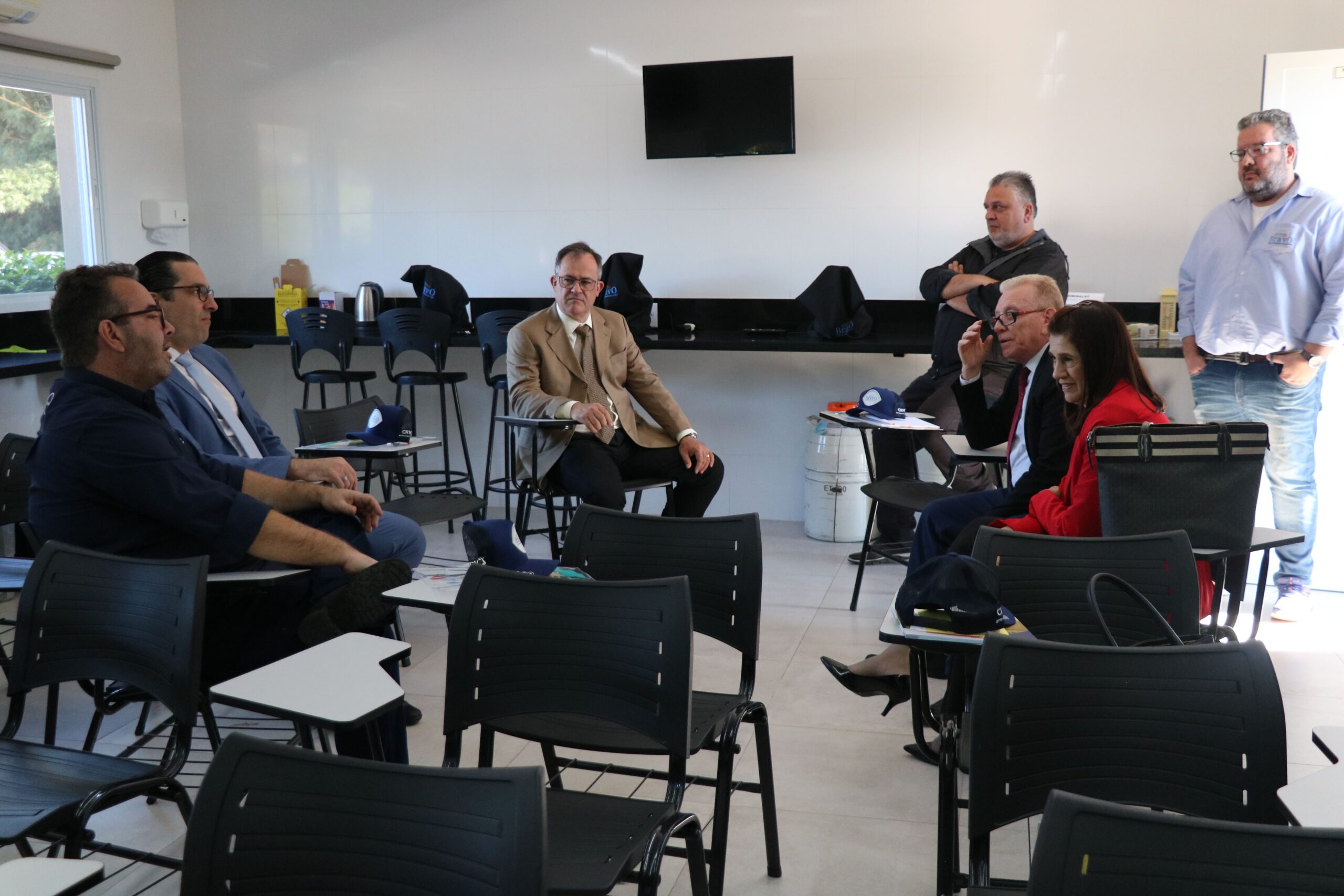 Na foto, membros do CRMV-SP e os gestores do CTA Bravo, os irmãos Fábio e Paulo Custódio, estão sentados, conversando.