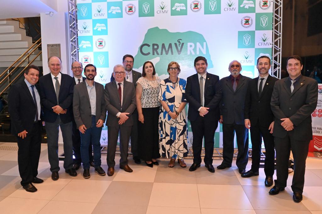 Representantes de diversas regionais do CRMV posam para a foto. Ao fundo, está o cartaz com o logo do CRMV-RN, em verde.