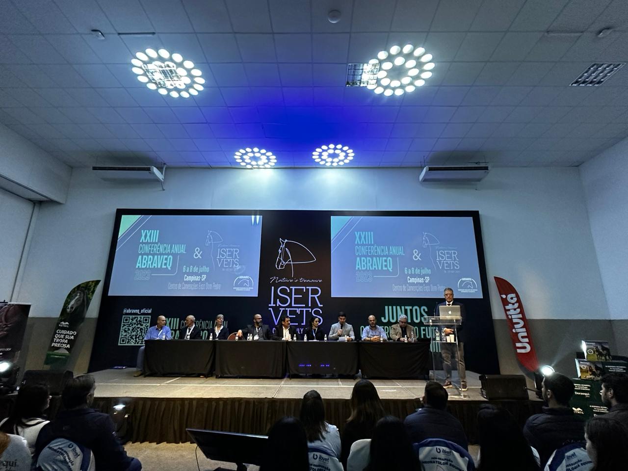 Imagem mostra palco com os principais participantes da Conferência Anual da Associação Brasileira de Veterinários de Equídeos