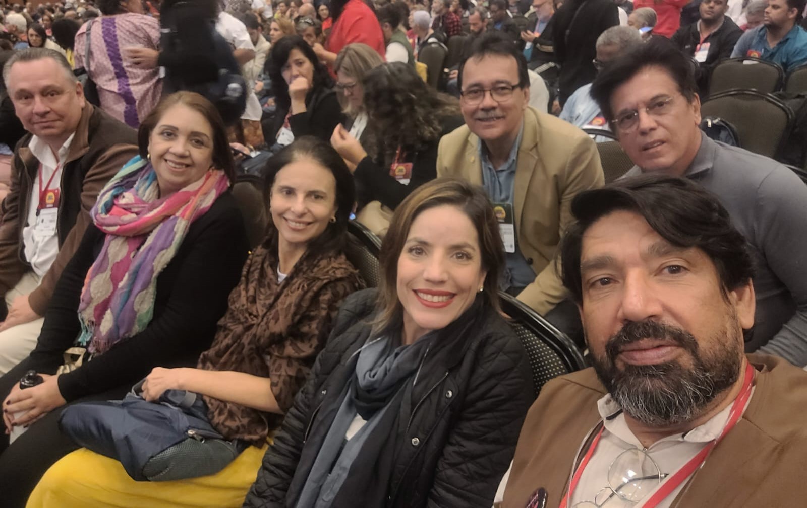 Na foto há sete pessoas, sendo três mulheres e quatro homens no auditório da 17º Conferência Nacional de Saúde. Estão sentados, em duas fileiras, posando para foto.