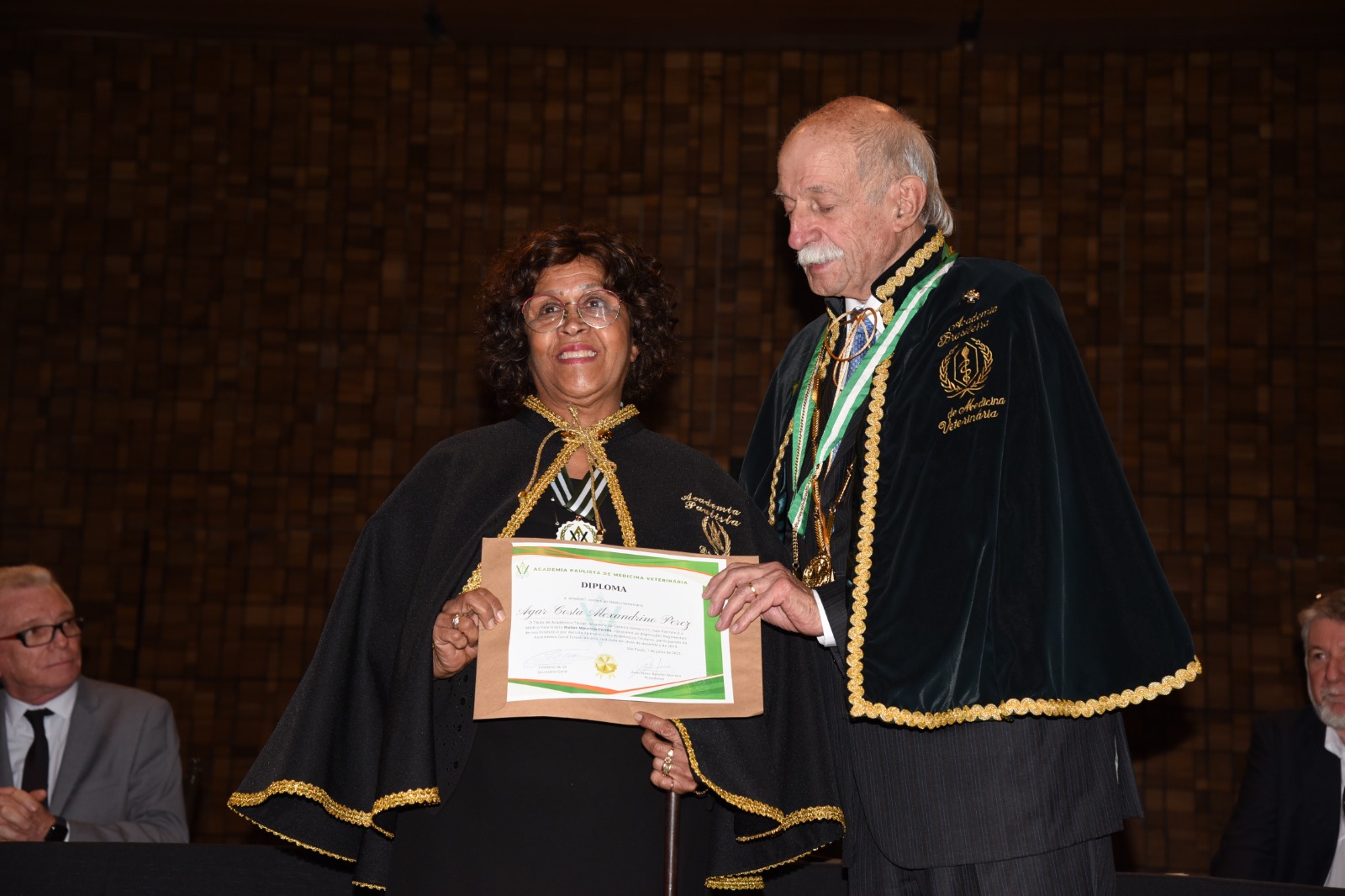 Agar Costa Alexandrino de Perez, presidente da Comissão de Aquicultura do CRMV-SP e Sebastião Costa Guedes, vice-presidente da Apamvet estão em pé, ela entrega a ela o diploma.
