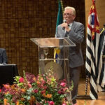 O presidente do CRMV-SP, Odemilson Donizete Mossero, está em pé no púlpito discursando.