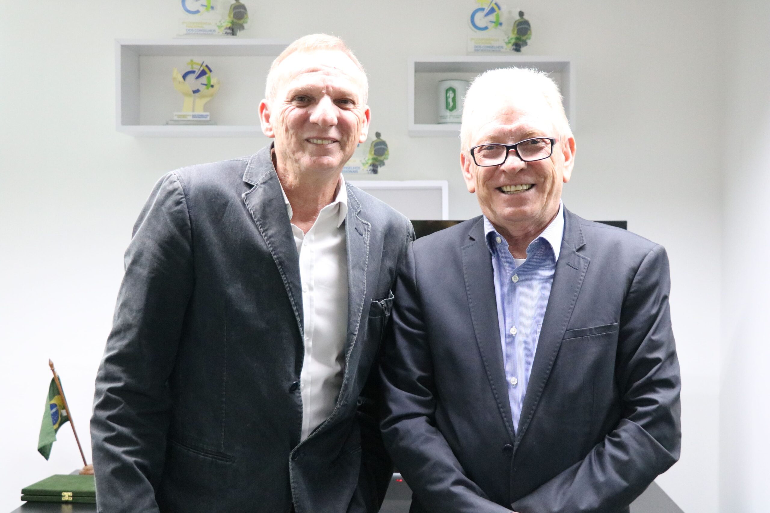 Na foto há dois homens de meia idade. Eles sorriem para a câmera posados lado a lado. Vestem terno cinza e camisa. Um deles usa óculos. Trata-se do presidente do Simdinvet e do CRMV-SP.