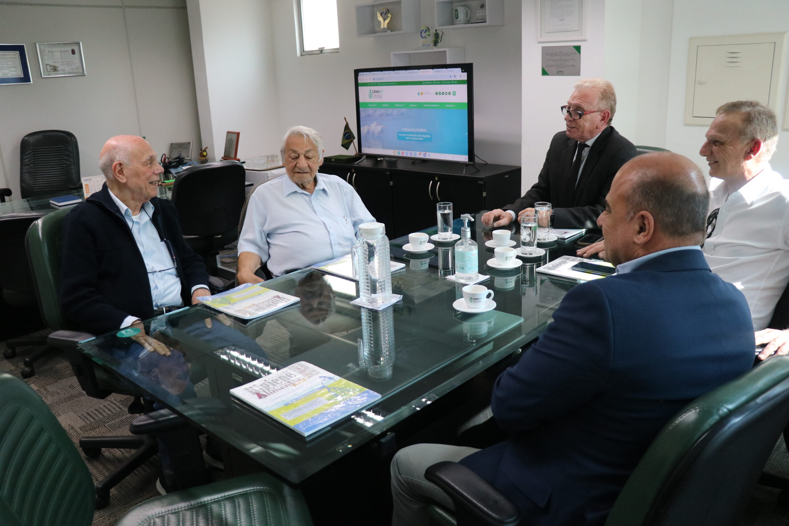 O presidente e o vice-presidente do CRMV-SP, junto aos ex-presidentes José Cezar Panetta e Jorge Antonio Chehade e o presidente do SindimVet, Robson Leporo, estão sentados em reunião, conversando assuntos da Medicina Veterinária.