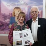 Posam para a foto o o assessor de Gabinete para assuntos parlamentares do CRMV-SP, Olírio Salletti Lobo, ao lado da vereadora Edir Sales, na Câmara Municipal de São Paulo. Ao fundo há o pôster com a foto e o nome da vereadora na cidade de São Paulo.