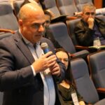 A imagem mostra em foco o vice-presidente do CRMV-SP, falando ao microfone no auditório.