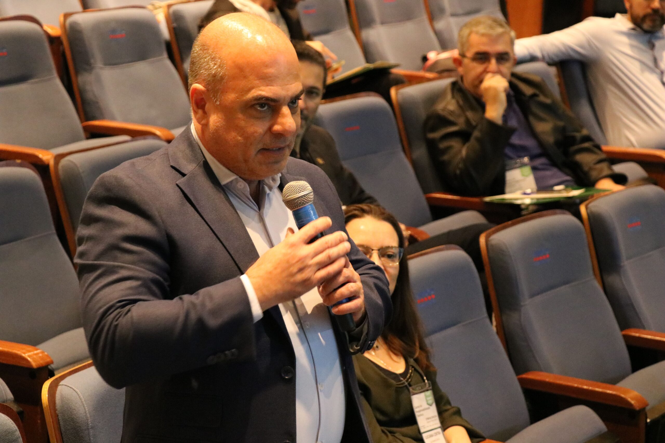 A imagem mostra em foco o vice-presidente do CRMV-SP, falando ao microfone no auditório.