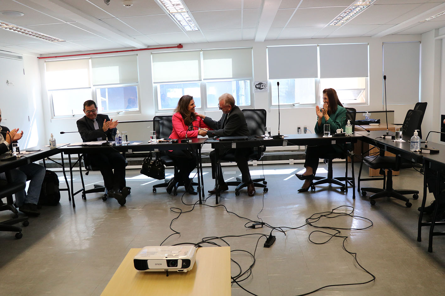 O presidente do CRMV-SP e a membro da Comissão de Agronegócio se cumprimentam. Ao lado de ambos, o secretário-geral e a tesoureira do CRMV-SP batem palmas, durante a posse.