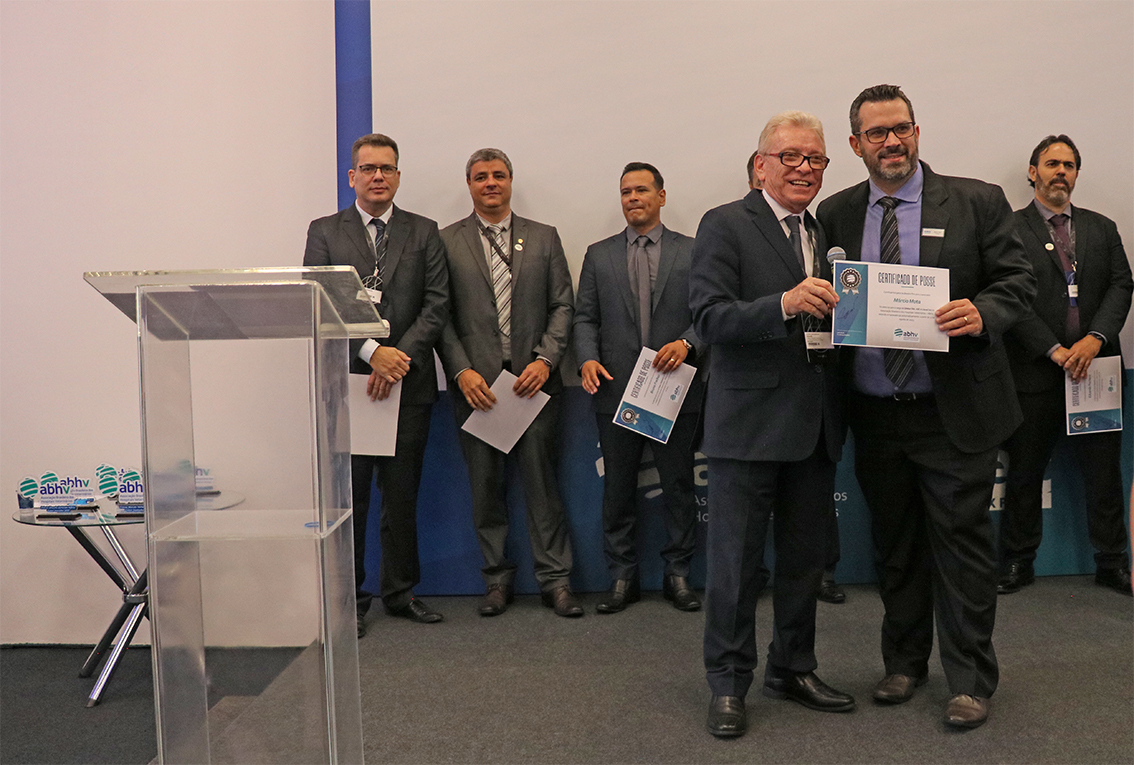 Na foto, Márcio Thomazo Mota, presidente da Comissão de Clínicos de Pequenos Animais e membro da Comissão de Entidades Veterinárias do Estado de São Paulo do CRMV-SP, recebe a nomeação do presidente do CRMV-SP, Odemilson Donizete Mossero. Atrás está o logo da Associação Brasileira de Hospitais Veterinários ABHV.