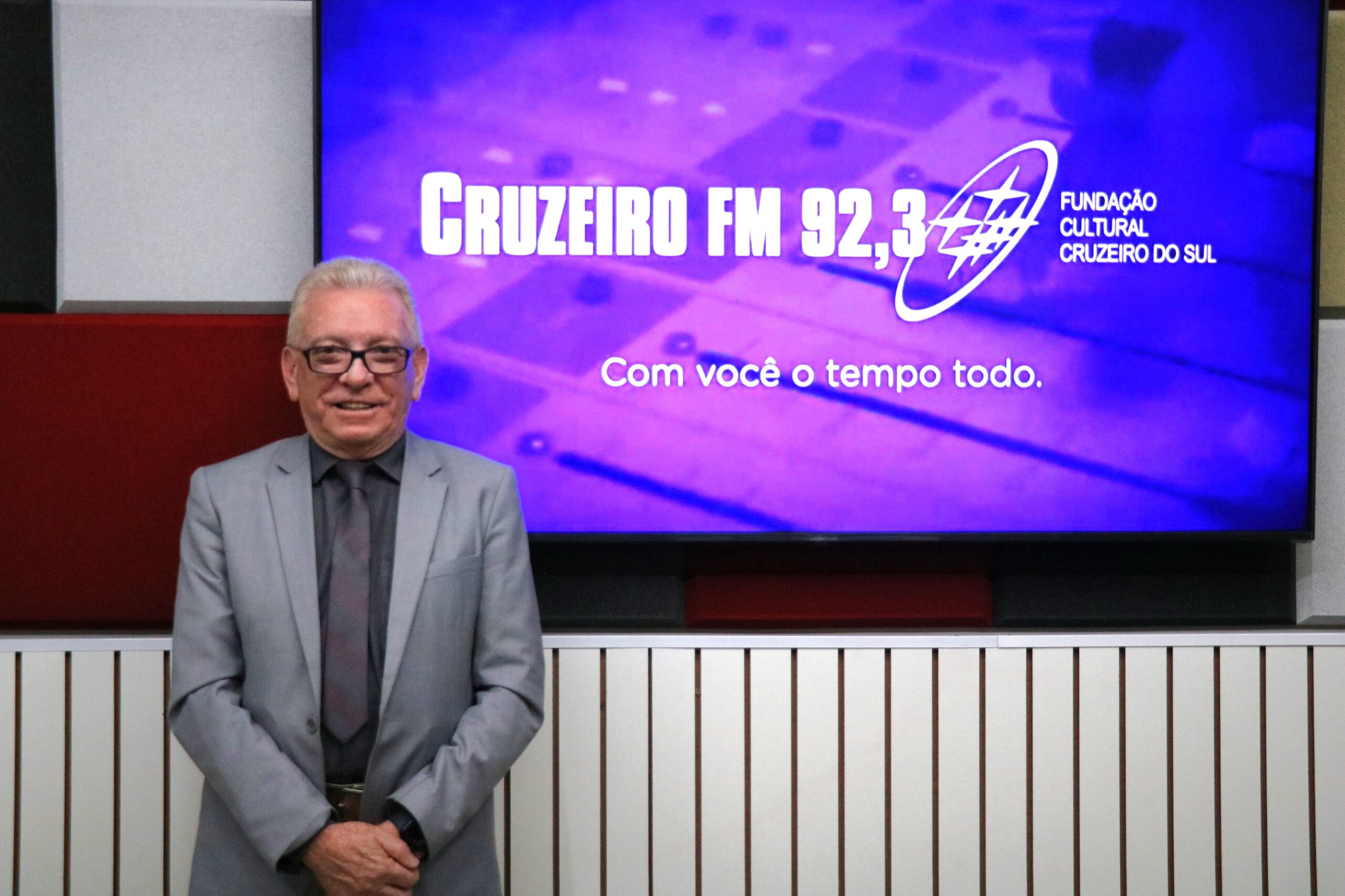 O presidente do CRMV-SP posa para foto. Atrás está o logotipo da Rádio Cruzeiro FM.